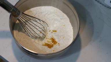 4. 新鲜柠檬用盐搓洗表皮后擦干，用柠檬刨刀刨取柠檬皮屑，加入混合好的粉类中，用蛋抽拌匀