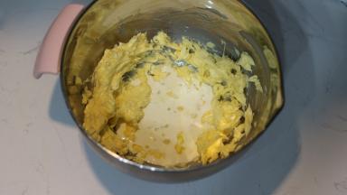 5. 室温彻底软化的黄油打发变白后，分3次加入淡奶油（淡奶油要提前加热至温热状态）。