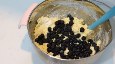 10. 将混合好的粉类材料倒入【步骤9】中，翻拌至略有干粉时加入2/3的蓝莓，快速拌匀