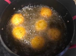 油锅烧至七成热下入裹好的土豆丸子，保持中小火炸至表面金黄即可。