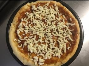 烤好的饼皮抹上适量的沙拉酱番茄酱，撒上一半的马苏里拉芝士。