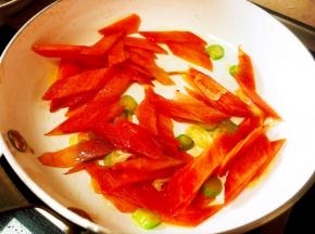 锅中留底油，放入葱爆香，入红萝卜片翻炒。