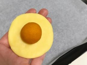 取一个小面团按扁，放上一份南瓜馅。