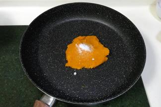 把南瓜泥放入不粘锅内进行翻炒，分三四次加入细砂糖和色拉油进行翻炒，南瓜泥会越来越稠。