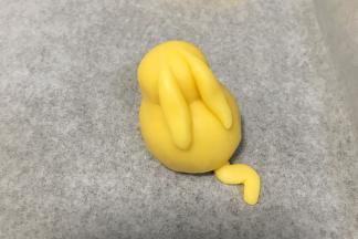 取少许小面团做出皮卡丘的耳朵和尾巴，粘到身体上。