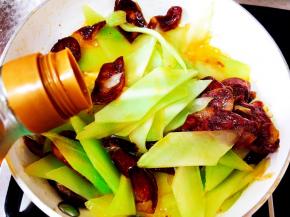 放入料酒，继续翻炒。