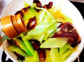 放入料酒，继续翻炒。