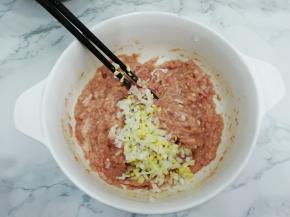 再把葱、姜碎放入肉馅中，搅拌均匀