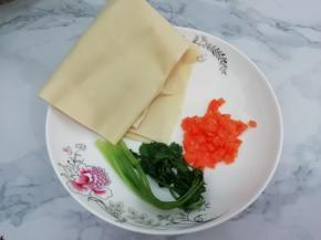 在准备干豆腐，胡萝卜和香菜，把香菜放入锅中，焯一下变软