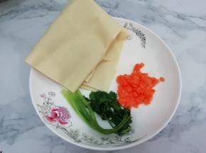 在准备干豆腐，胡萝卜和香菜，把香菜放入锅中，焯一下变软