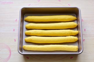 依次把所有的面团全部做成长条状，摆放在模具里面