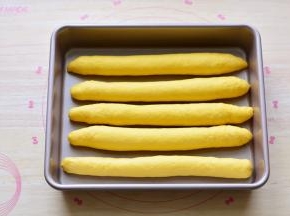 依次把所有的面团全部做成长条状，摆放在模具里面