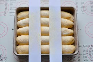 放进烤箱，30度进行二次发酵，发酵至两倍大即可，发酵好的面团，用纸剪成两个长条状，放在面团上面，筛上高筋面粉