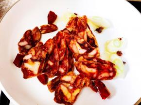 放入腊肠翻炒。