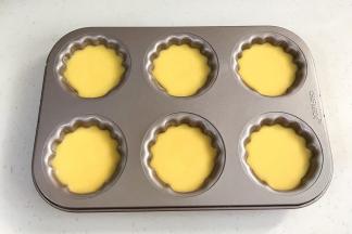 给模具涂上黄油防粘，接着倒入面糊，8分满，轻轻震动下，排出气泡。