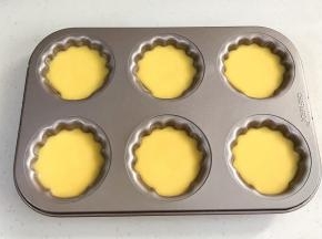 给模具涂上黄油防粘，接着倒入面糊，8分满，轻轻震动下，排出气泡。
