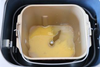 将水、全蛋液倒入面包机的面包桶中，盐、糖对角放；