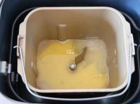 将水、全蛋液倒入面包机的面包桶中，盐、糖对角放；