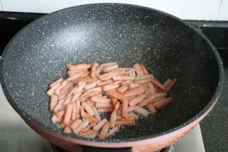 面团发酵的时候可以来准备内馅,将午餐肉切小条后放入锅内煎炒至表面金黄；