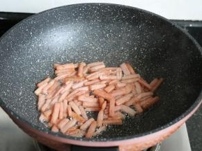 面团发酵的时候可以来准备内馅,将午餐肉切小条后放入锅内煎炒至表面金黄；