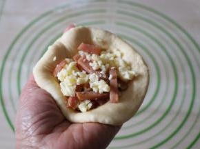 翻面后包入适量内馅，像包包子那样收紧收口；