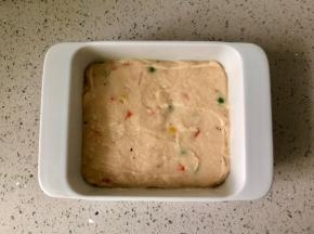 取一个方形的容器，底部和四周抹一层油，然后把鸡肉泥倒进去，用勺子或硅胶刮刀抹平表面。