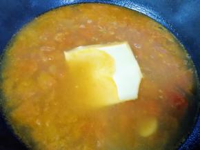 大概10分钟左右，番茄汤变浓，加入芝士片煮至芝士片融化，放盐和鸡精调味。