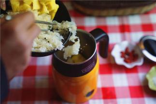 将洗切好的银耳及菠萝块入养生杯里。将食材装至半杯的位置就可以。