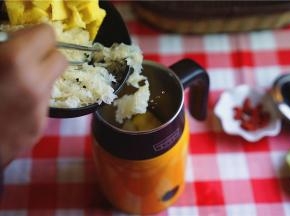 将洗切好的银耳及菠萝块入养生杯里。将食材装至半杯的位置就可以。