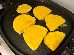 电饼铛预热好之后，刷一层油，然后把鸡蛋馒头片放入煎制。