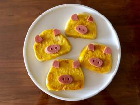 把小猪的耳朵和鼻子放到馒头片相应的位置上。