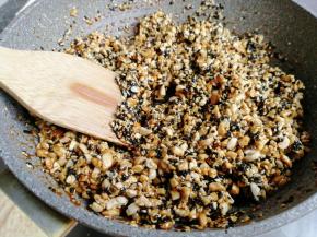 立即把花生芝麻倒入锅里，并翻拌均匀，使每一颗花生和芝麻都粘上糖浆