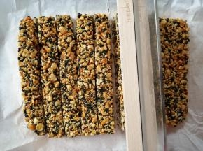 将油纸提起，放在砧板上，用利刀将它切成小块，不要等糖全放凉才切哟，会难切很多