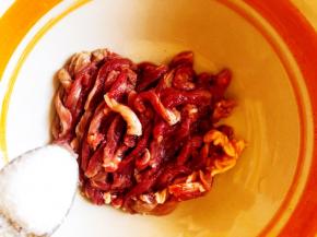 将肉切成均等的丝，加入盐。