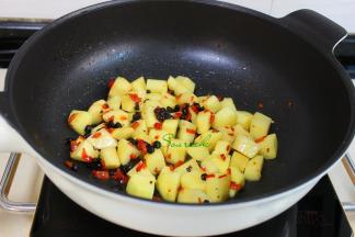 热锅，到少许油，小火煸炒辣椒和豆豉，倒入土豆，改为旺火爆炒至外皮焦脆，加少许盐炒均，这样的土豆没有熟就要出锅。