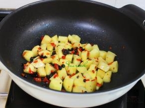 热锅，到少许油，小火煸炒辣椒和豆豉，倒入土豆，改为旺火爆炒至外皮焦脆，加少许盐炒均，这样的土豆没有熟就要出锅。