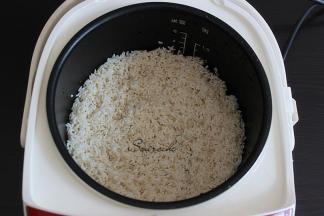 大米洗净浸泡10分钟，倒入电饭锅，加适量的水，比平时煮饭的水少一边，盖子盖子按煮饭键。大米浸泡不仅省电，米饭更加香软。