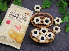 烤好的饼干放凉之后，把实心的饼干涂一层蓝莓果酱，然后盖一片镂空的饼干，用手压紧