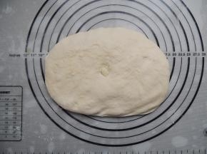 发酵好的面团倒出来，轻轻按压，排出面团里面的空气。