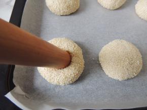 用擀面杖从面团中心位置往下按压，直压入底部。