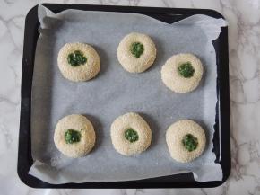 擀面杖拿下来以后，面团中间会出现一个深窝状，在里面填入适量葱花馅料。