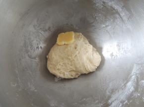 启动厨师机，将面团揉至光滑以后，加入软化的黄油。