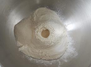 将所有的干性材料全部放入厨师机的搅拌桶中，酵母粉放在中间，不要和糖、盐接触。