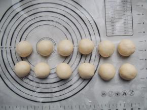 发酵好的面团倒出来，轻按排气，分割成12个等份的小面团，分别揉圆，盖上保鲜膜松弛20分钟。