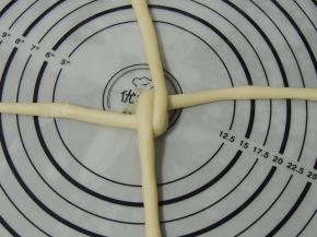 然后将竖向那股长条上下折叠，交错压住第一股。