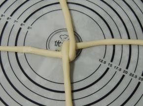然后将竖向那股长条上下折叠，交错压住第一股。