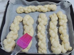 发酵好之后取出烤盘，同时200度预热烤箱。在面团表面刷一层薄薄的蛋液，撒上白砂糖。