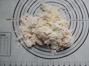 先用筷子将所有材料搅拌至看不见干面粉的絮状，然后倒在揉面垫上。