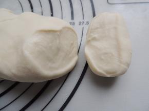 少量多次加入干面粉，不断按揉排气，将干面粉揉进面团里面，直到切开面团，截面细腻光滑，看不见气泡就可以了。