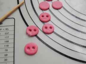 用筷子在圆形面片上扎出两个小孔，当做猪鼻孔。一共需要十个圆片。